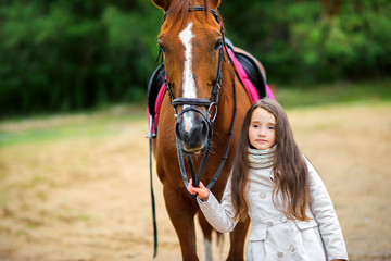 Obraz premium teen girl walks with her favorite horse.