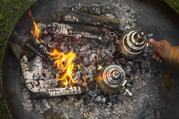 A traditional way of making Maroccan mint tea on an open fire