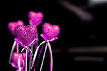 Fototapeta premium Valentines day. Pink hearts on black blurred background close-up with copy space for congratulation 