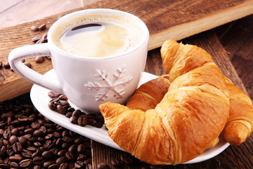 coffee and croissant with coffee beans. breakfast energy concept.
