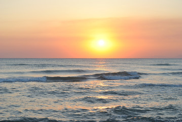 Fototapeta na wymiar orange sunset on the sea waves