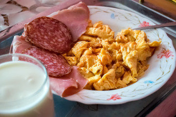 breakfast with scrambled eggs, sausage and yogurt