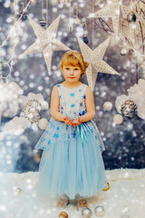 
Two little girls sitting near the Christmas tree and wait for the New year
