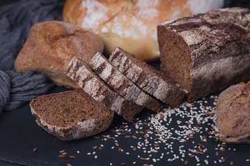 Assortment of baked bread on dark background.
