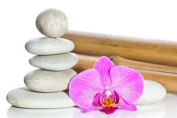 Bamboo, stones, stacked pyramid and flower of a pink orchid on a white background