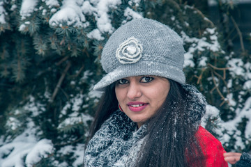 Beautiful Indian woman in a red coat in winter