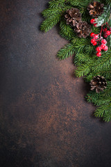 Fir tree pine cones and decorations on dark stone table.