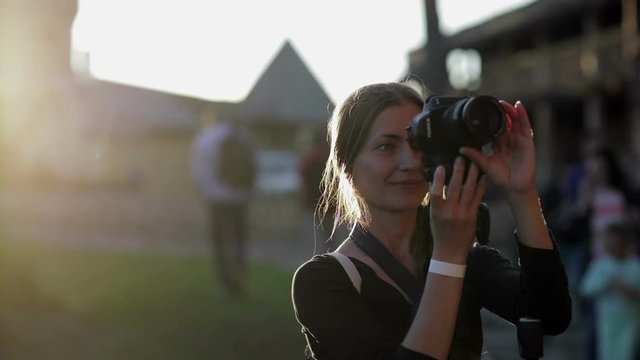 Girl is taking a photo and smiling outdoor