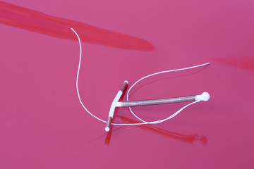 Intrauterine device with copper on red background