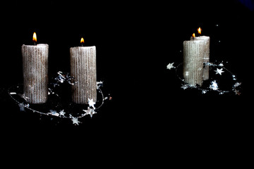 Two Christmas silver candles, reflection in mirror