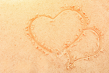 photo two hearts painted on the sea sand on the shore close-up