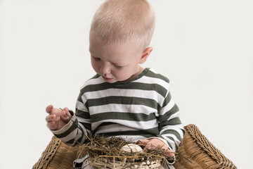 A happy boy holds a bird's nest with an egg in his hands..The bird twisted the nest on the tablet. We will save the earth..The concept of environmental protection.