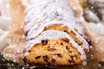 Dresdnen Stollen is a Traditional German Cake with raisins on a light knitted background.Gift for Christmas.Vintage style.Fruit cake for the Holiday. German, European festive dessert.Drawn Snowfall