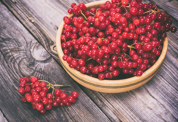 bunch of red viburnum in a wooden bowl