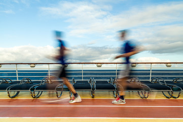 Blurred Joggers on cruise ship running track