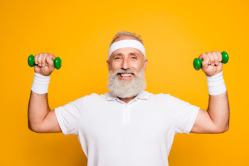 Fototapeta na wymiar Cheerful emotional cool grey haired grandpa with humor grimace exercising holding equipment, lifts it with strength and power. Body care, hobby, weight loss, lifestyle, game process