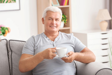 Handsome mature man with coffee at home
