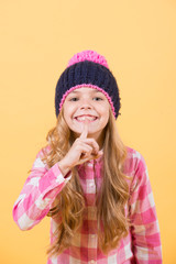 Child with long blond hair put finger to lips