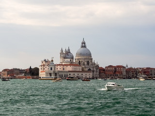 Fototapeta na wymiar View of the dome and Santa Maria della Salute in Venice from the water with a power boat in the foreground