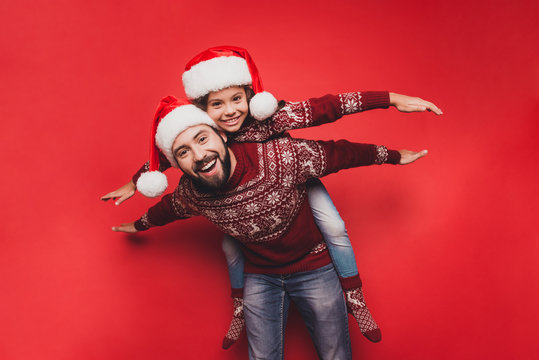 Handsome dad with small adorable sweet cute girl fooling around, excited in knitted cute traditional x mas costumes with ornament, head wear, december, noel time, freedom, celebrate, winter