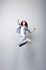 Fototapeta na wymiar I did it! Dreams come true! Concept of freedom, happiness and life without problems. Vertical full length portrait of happy crazy woman is jumping up, isolated on grey background