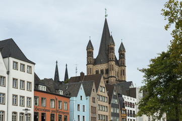Fototapeta na wymiar COLOGNE, GERMANY - SEPTEMBER 11, 2016: Colorful houses in Bavarian style and the Romanesque Catholic church 