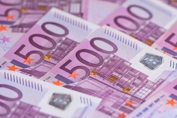 Money background consisting of purple five hundred Euro bills spread across the screen