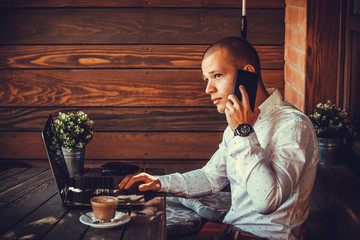 Young man talking by phone in cafe