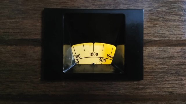 Retro backlit radio search scale on wooden background. Art deco valve tuner from 1933.