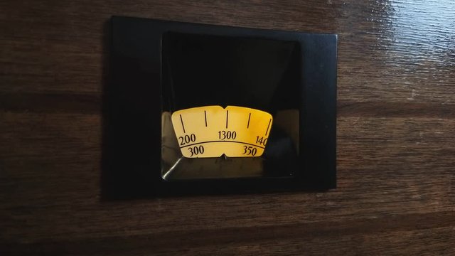 Retro backlit radio search dial on wooden background. Art deco tuner from 1933. view on angle