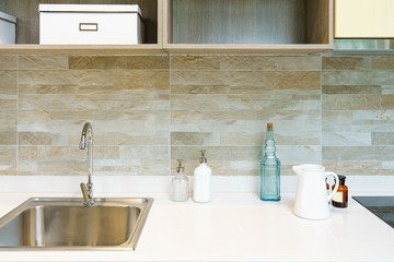 Modern kitchen furniture with contemporary kitchenware like hood, black induction stove and oven in house.