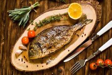 baked dorado \ dorada fish on a dark wooden background, top view