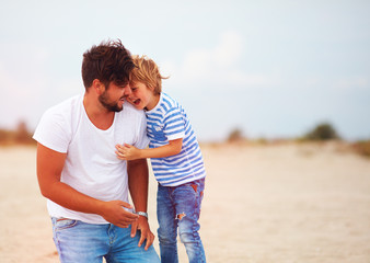 candid image of father and son laughing, having fun together
