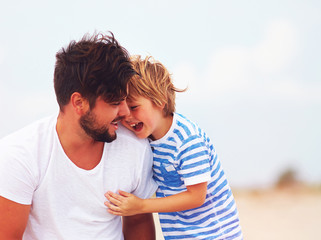 candid image of father and son laughing, having fun together