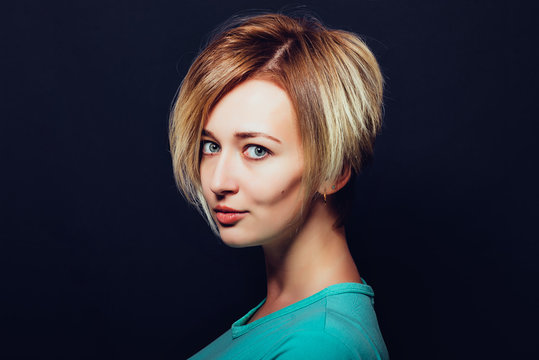 Woman with short haircut on a dark background close-up