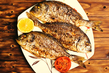 baked dorado \ dorada fish on a dark wooden background, top view