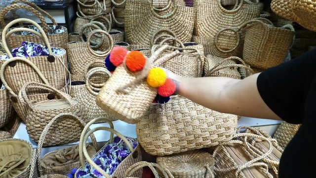 Female Customer Choosing Trendy Woven Straw Bags For Summer. 4K. 