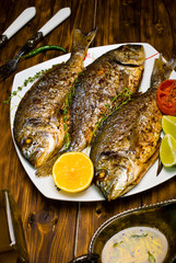 baked dorado \ dorada fish on a dark wooden background, top view