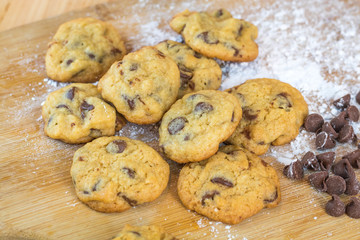 Freshly baked chocolate chip cookies on wooden board, selective focus