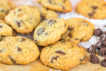 Freshly baked chocolate chip cookies on wooden board, selective focus