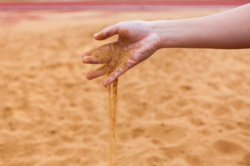 Sand in man's hand blur background select focus