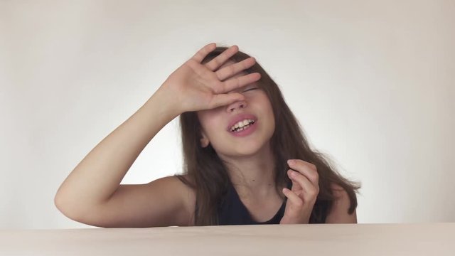 Beautiful sad teenage girl expresses despair and cries on white background stock footage video