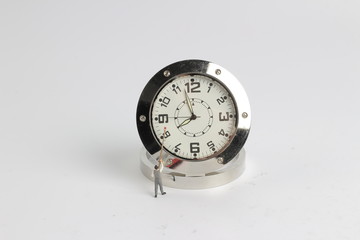  mini  people figure standing on clearing clock