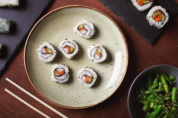 Japanese sushi and green beans on a dark wooden background