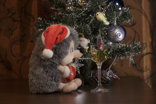 Plush Hedgehog as Santa Claus and a glass of White Wine. Christmas decorations.