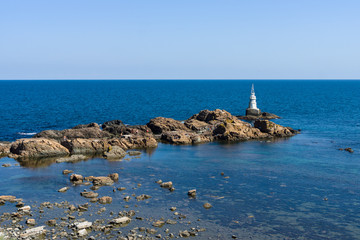 Fototapeta na wymiar A lighthouse on the rocks. Black Sea. Ahtopol. Bulgaria.