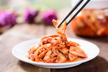 Korean food, kimchi cabbage on white dish with chopsticks for eating.Healthy food