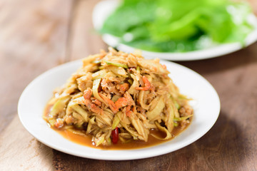 Thai food,spicy mango salad on white dish with vegetable