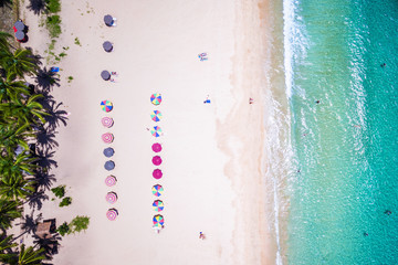 Fototapeta na wymiar Top view of beach with colorful umbrellas and people bathing in El Nido, Palawan, Philippines.