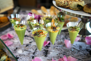Green avocado coctail shots served on catering buffet table